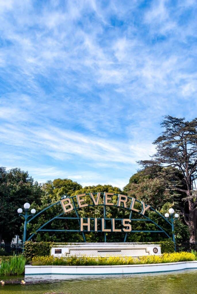 Iconic Beverly Hills sign in a beautiful outdoor park scene with blue sky and greenery.